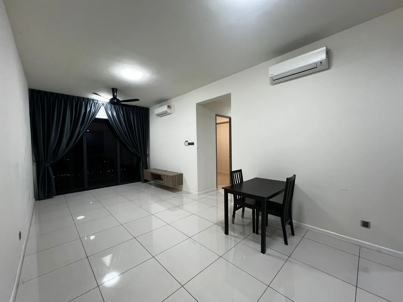 Living features: white painted walls, glossy white tile flooring, 5-blade ceiling fan with light, floor-to-ceiling windows, blackout curtains, dining table for 4, 4 black dining chairs, wall-mounted TV console, air conditioning unit; style: modern; view: city.
